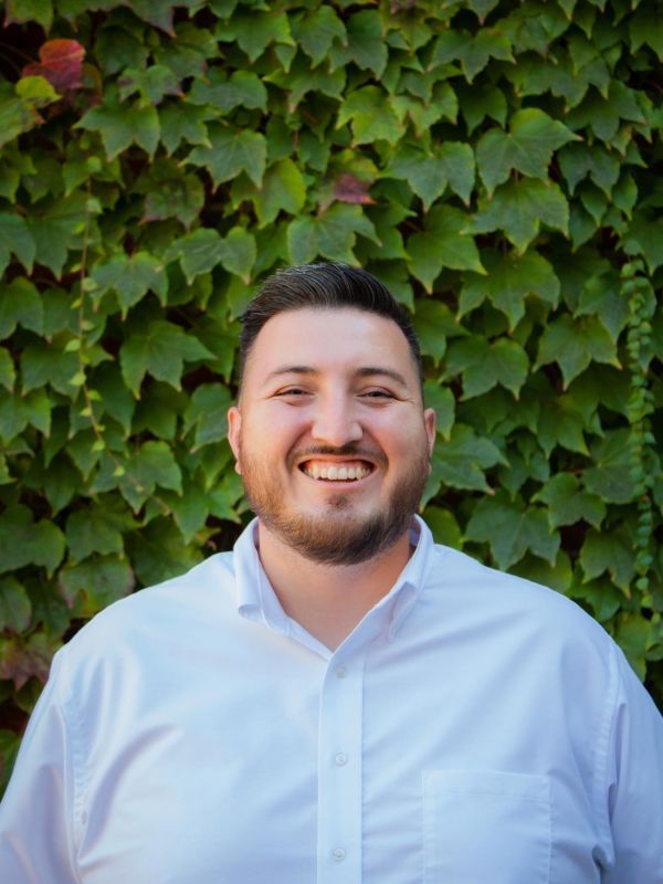 Jesse Magaña standing in front of ivy outside of DeRosa University Center