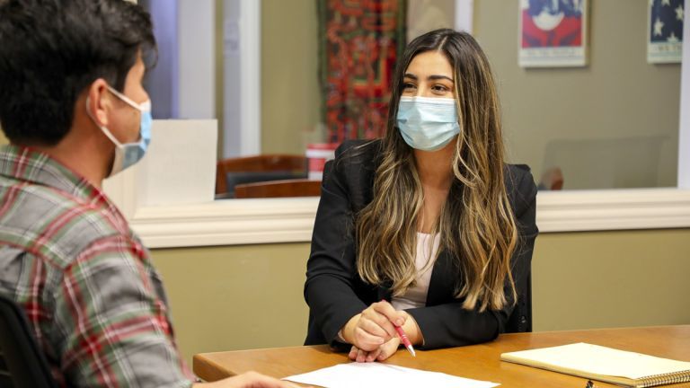 Third-year law student Flora Feizi assists a local Afghan resident filing a Humanitarian Parole application on behalf of a loved one. 