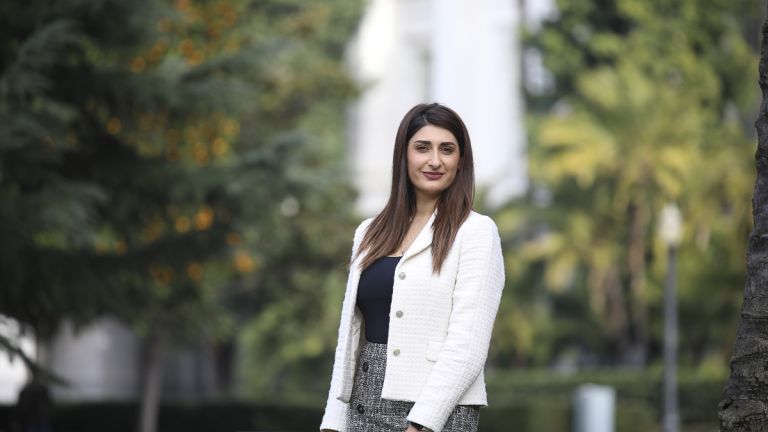 A McGeorge student in a white blazer standing outside the California State Capitol Building.