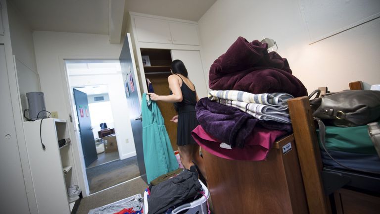 a student puts away her freshly laundered clothes