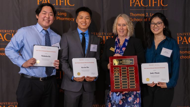 Pharmacy students and Dean Gunderson posing with certificates. 