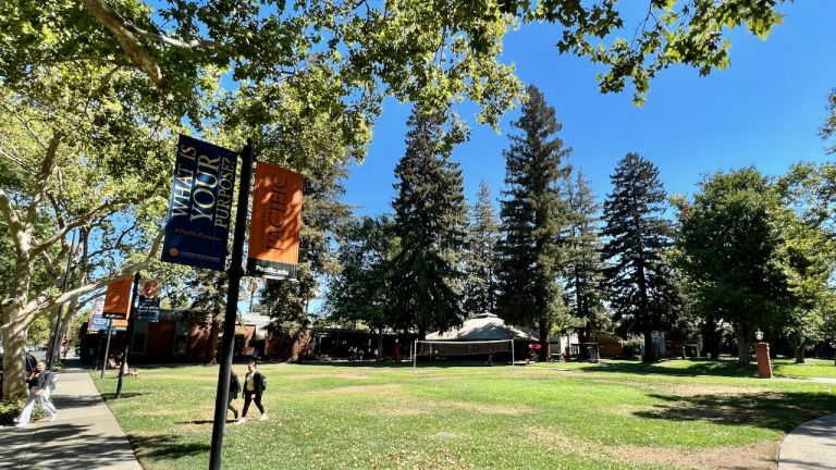 Photo shows students walking across the Quad at the Sacramento campus. 