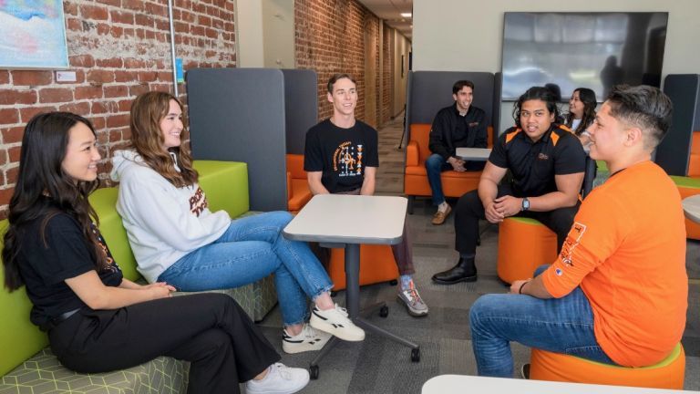 Photo shows a group of OT Students talking in the lobby of the Chan Family Health Education Building