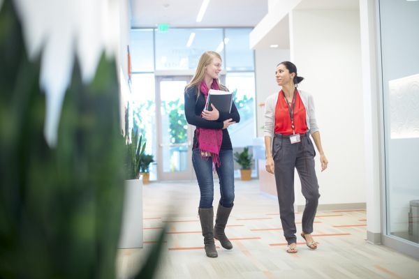 two people talk in a hallway