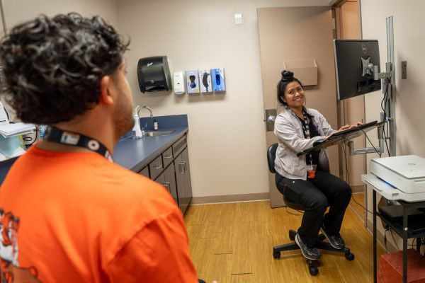 A nurse practicioner speaking to a male patient.