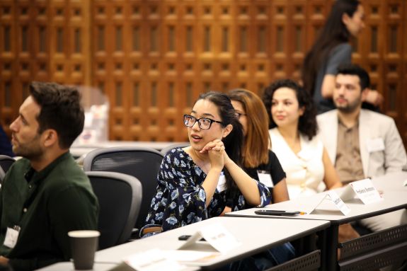 LLM students look behind them at their professor teaching 