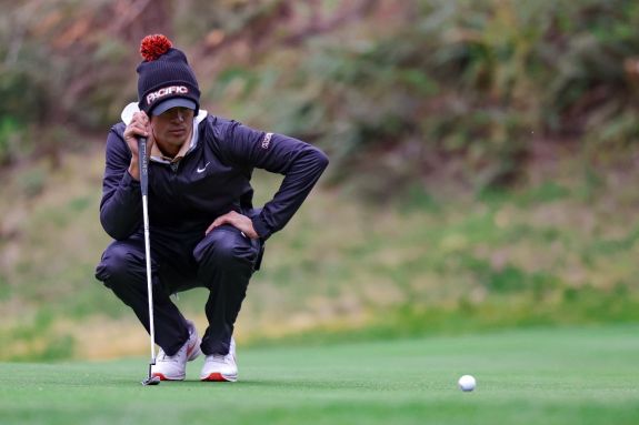 Men's golf player lines up a shot.