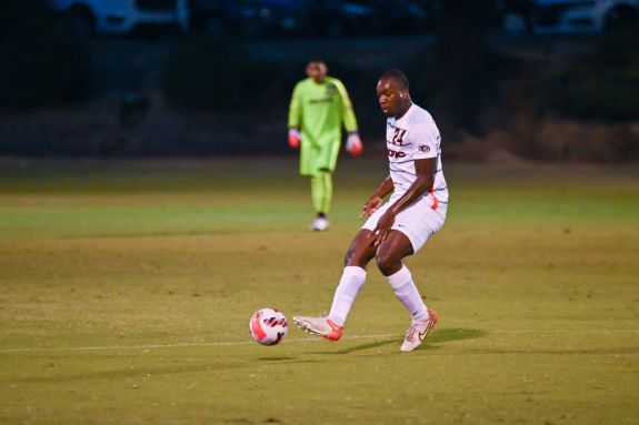 Soccer player dribbles the ball.