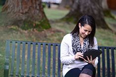 lady reading on a bench in the quad