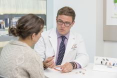 student showing hearing aids to patient in audiology clinic