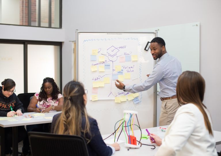 students interact with professor in classroom