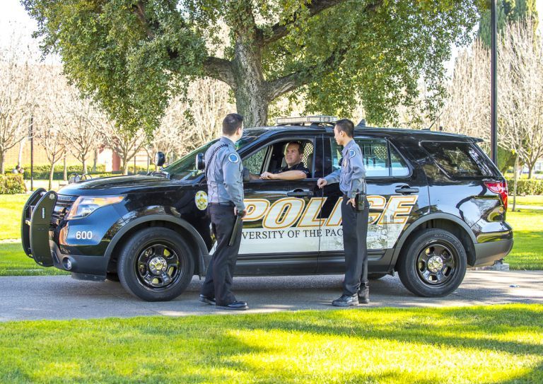 public safety employees gather by a vehicle