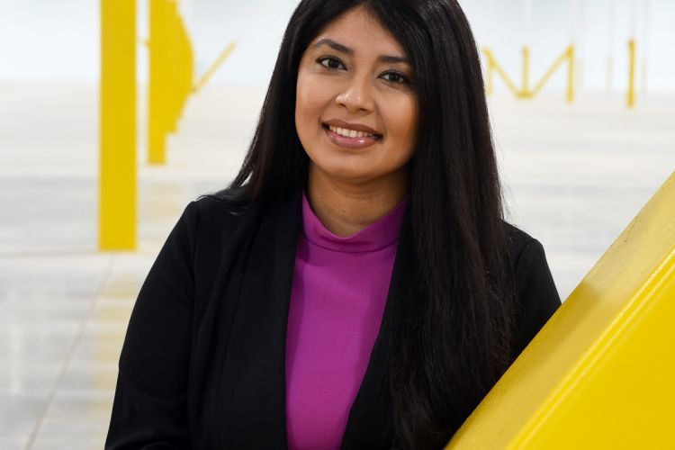 A portrait of Mariana Corona Sabeniano in front of a yellow and white backdrop