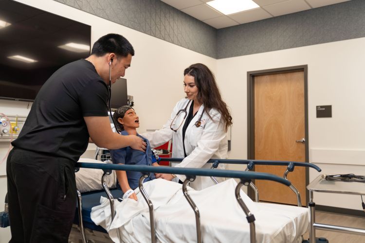 nursing students work with a mannequin in the clinical skills lab