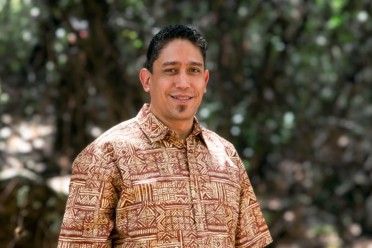 A close up photo of a man in a patterned shirt