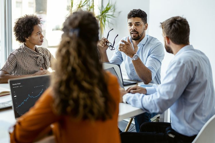 four people sitting at an office table