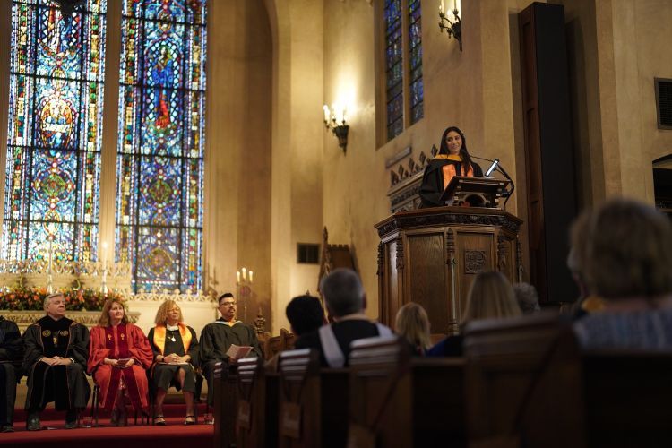 a student stands at a podium inside Morris Chapel