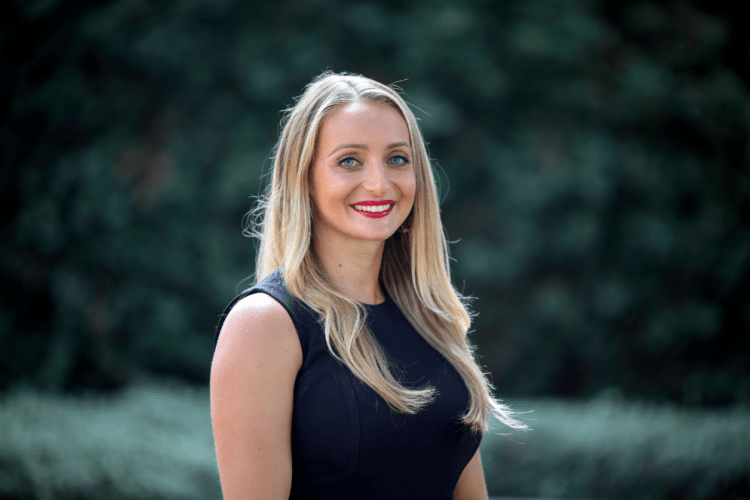 woman in black shirt smiles for a headshot 