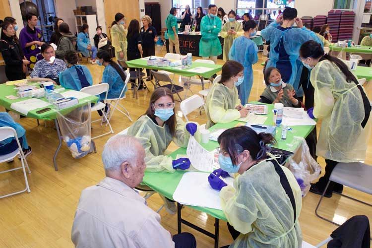 room with people dressed in personal protection equipment and members of the public being served