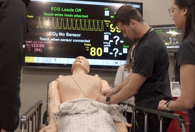 physician assistant students practice on a medical manikin