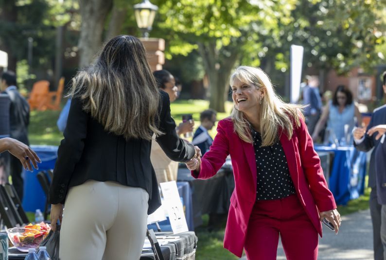 Two women shake hands at a career fair