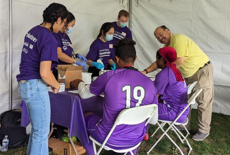 Special Olympics Healthy Smiles table with people