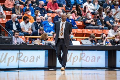 Leonard Perry walks on the side of the court at a basketball game