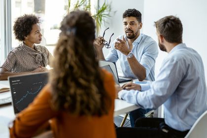 four people sitting at an office table