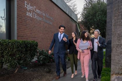 Four people walk together outside the Eglet Center for Advocacy and Dispute Resolution