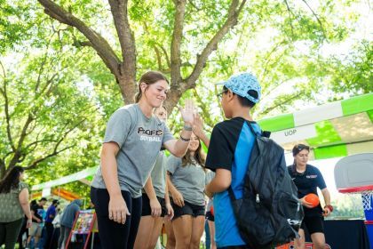 softball player high fives child