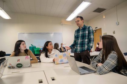 a professor works with a group of students