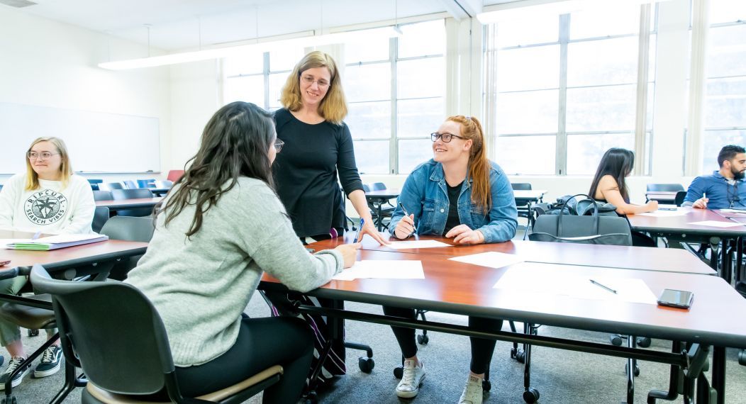 students interact with professor in classroom