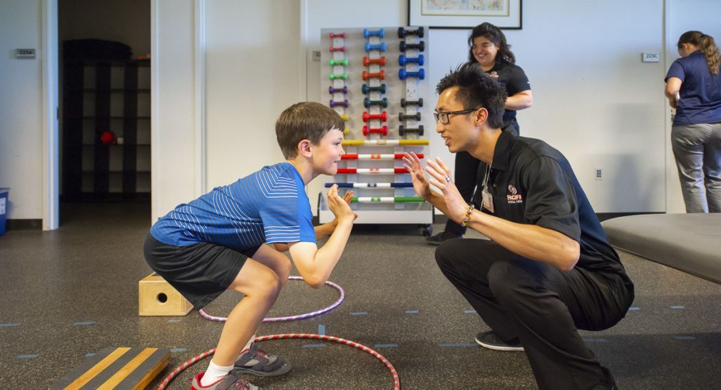 a physical therapy student works with a child during a clinic