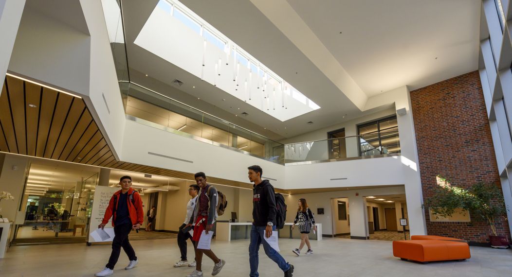 students walk in the lobby of the library