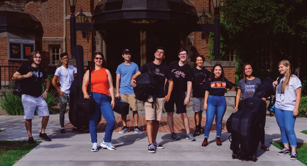 music students standing in front of Faye Spanos Concert hall