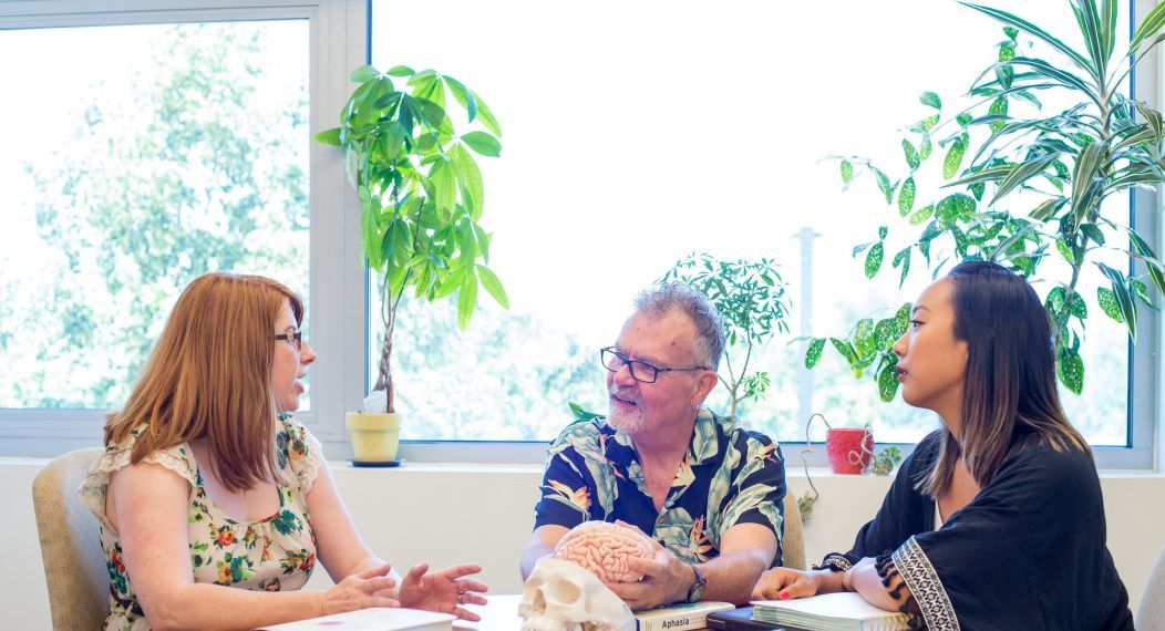 SLP professors talking around table