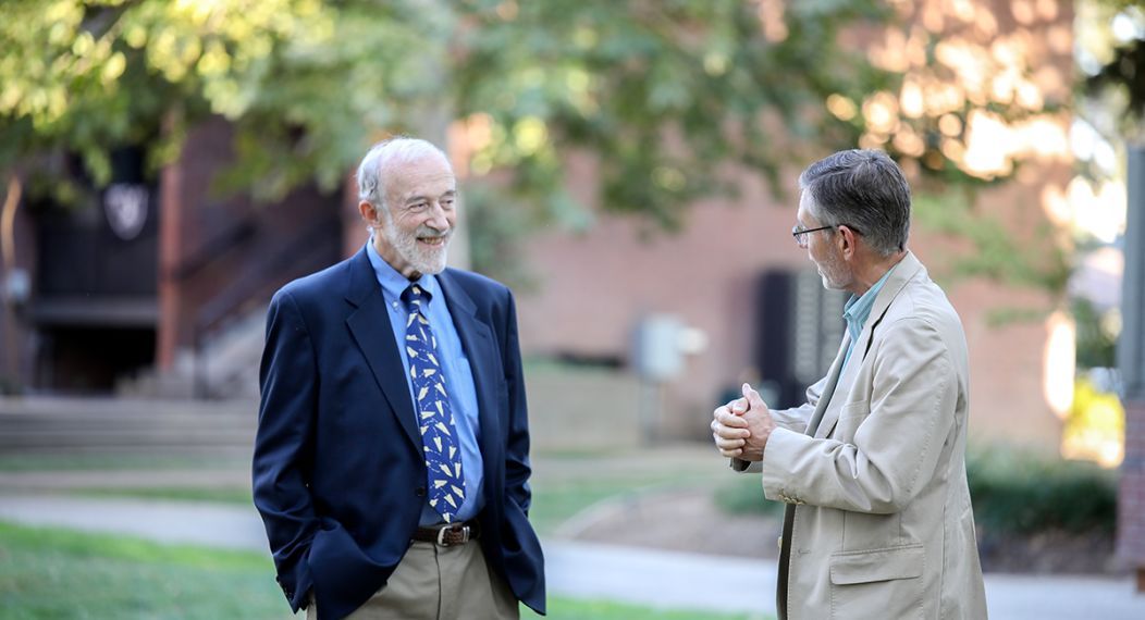 John Kirlin talking to another person in the Quad