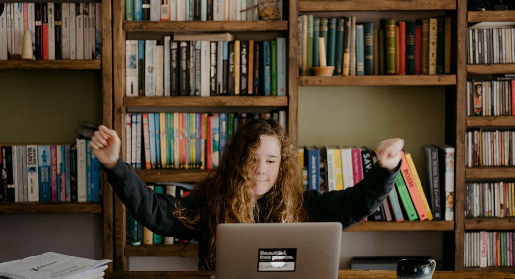 student in front of laptop in library area