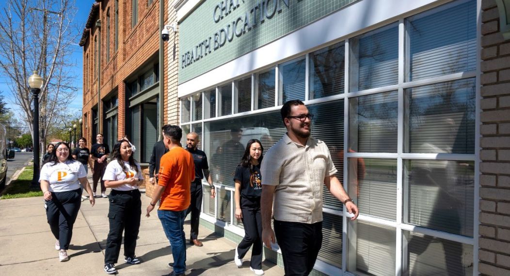 OT students walk down a sunny sidewalk