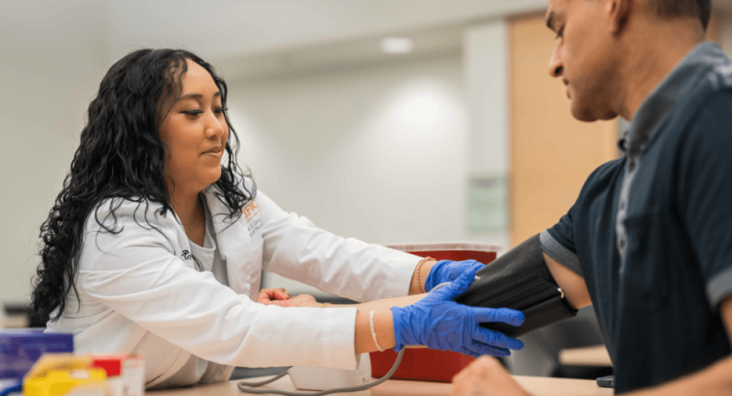 a man's blood pressure is checked by a health professional