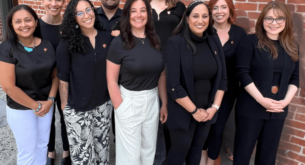 Photos shows the faculty & staff of the OT Department standing against a brick wall. 