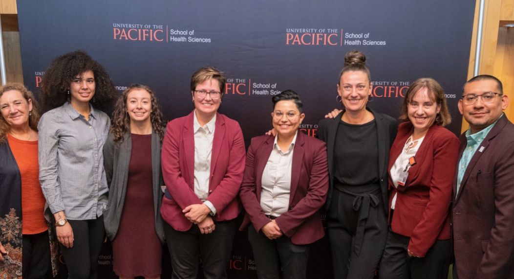 Image features 9 faculty & staff members of the MSW program standing in a row.