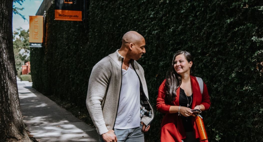 Photo shows two students walking on the Sacramento campus. 