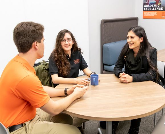 education students sitting around a table talking