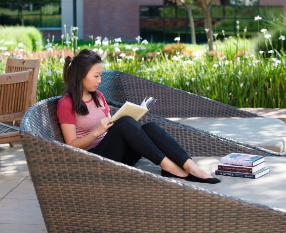 student reading in front of DeRosa Center