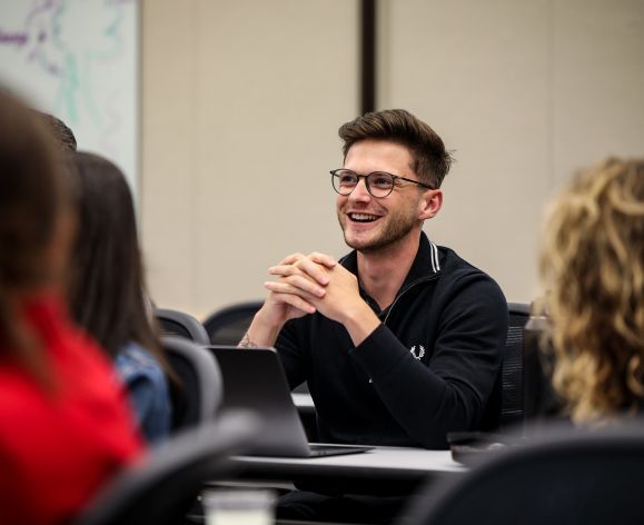 A student smiling in a classroom