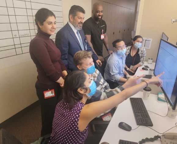 people gathered around monitor looking at sleep study results